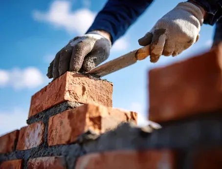 Mason laying brick in fresh mortar on a Colorado masonry repair